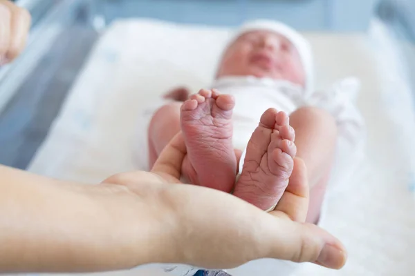 depositphotos_607064452-stock-photo-mother-holding-newborn-baby-feet